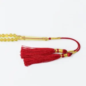 كركوشة مسباح كهرب شفاف نواعم حمراء مزينة بخيوط ذهبية بوزن 10.5 غرام - Transparent Amber Nawaem Misbaha with Red and Gold Tassel 10.5g {A10}