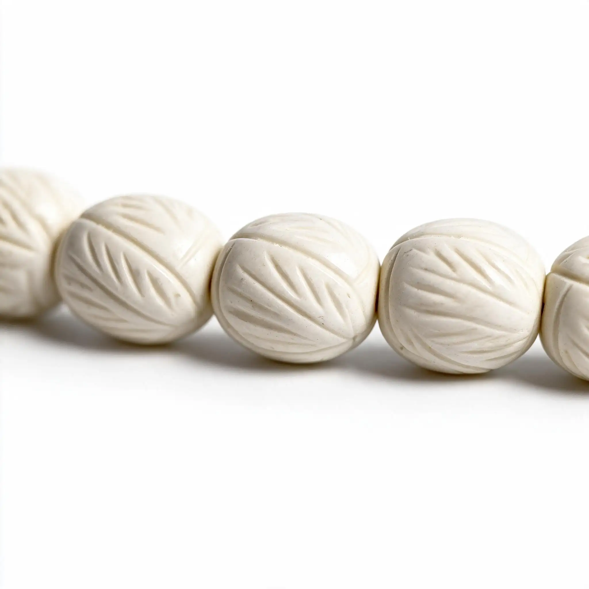 carved-camel-bone-rosary-macro-p4 تفاصيل قريبة تبرز نقوش أوراق الشجر الحفرية المتقنة على حبات مسباح عظم جمل منقوش othmani.co